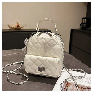 Detail of white quilted mini backpack with chain strap and silver twist lock closure