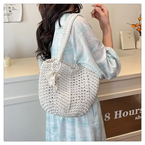 Detail of woven cream tote bag with cute bunny plush pendant and pearl charms