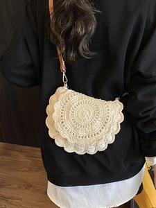 Bohemian crochet saddle bag in cream white with brown leather strap worn by a model