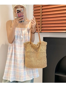 Beige woven straw tote bag with brown leather handles and crochet hollow-out pattern