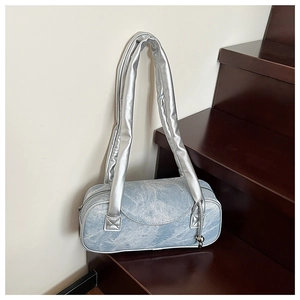 Dettaglio della borsa a cuscino in denim azzurro con tracolla imbottita argento