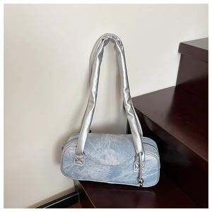 Dettaglio borsa a cilindro in denim blu vintage con finiture argento e cerniera lampo