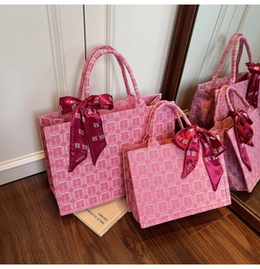Detail of pink bridal tote bags featuring Double Happiness jacquard and silk bow decoration