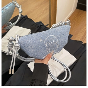 Détail du sac bandoulière en denim bleu clair avec broderie chiot et bandoulière nouée