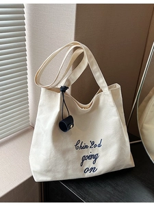 Sac fourre-tout minimaliste en toile avec broderie bleue et breloque cylindrique