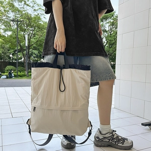 Detail eines multifunktionalen Nylon-Rucksacks mit Kordelzug in Beige und Marineblau