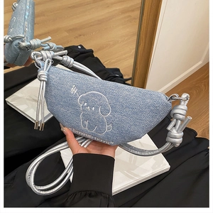 Détail du sac à bandoulière en denim bleu clair avec broderie de chien blanc mignon