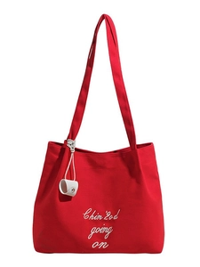 Sac fourre-tout en toile rouge avec broderie blanche sur un fond blanc impeccable