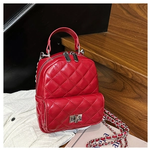 Detail of red quilted faux leather mini backpack with silver metal chain and twist lock