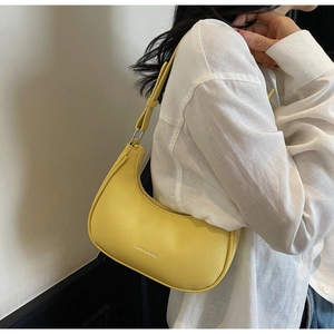 Detailed texture of yellow lychee leather crescent bag with silver metallic hardware
