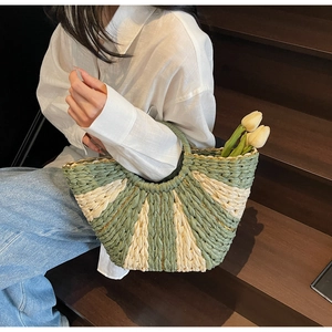 Close-up of contrast woven straw bag with green and cream stripes and tulip detail