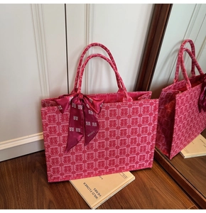 Detailed shot of red Chinese wedding tote bag with Xi character jacquard and silk bow