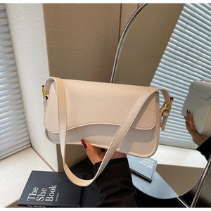 Detail of white litchi pattern leather bag with wave-shaped flap and gold hardware