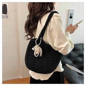 Detail of black woven shoulder bag with pearl chain and cute rabbit plush charm decor