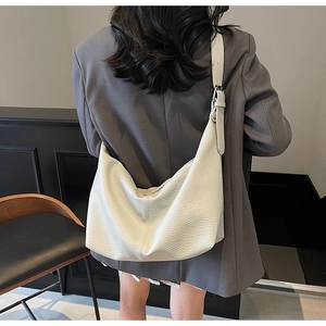 Detail of white lychee leather hobo bag showing soft texture and adjustable silver buckle