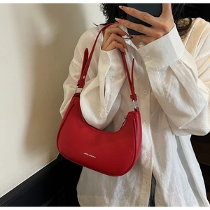 Detailed macro view of the red lychee pattern leather and adjustable shoulder strap on bag
