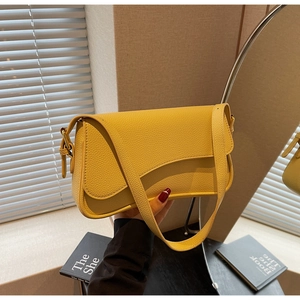 Close-up of bright yellow lychee grain leather texture on an elegant shoulder bag