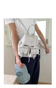 Detail of cream white pebbled leather backpack with drawstring closure and front buckle pockets