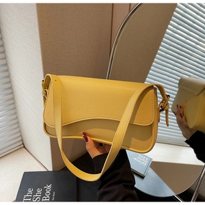 Close-up of bright yellow litchi grain leather shoulder bag with adjustable strap