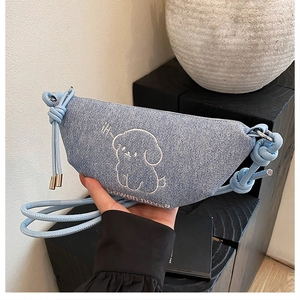 Détail du sac croissant en jean bleu clair avec broderie chien et bandoulière nouée