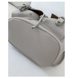 Close-up of litchi texture leather and silver metal buckles on a designer backpack