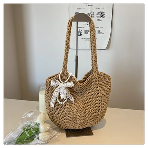 Detailed close-up of woven tote bag with white lace bow and lamb plush pendant charm