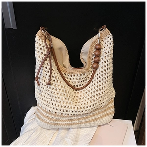 Detailed shot of bohemian woven tote bag showing wooden beads and leather handles