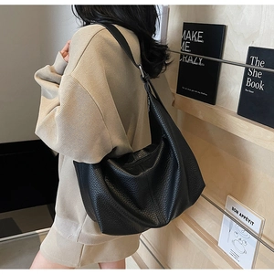 Detail of black lychee-grain hobo bag showing the texture and large capacity fit