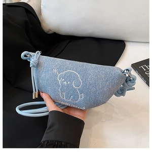 Détail du sac croissant en jean bleu clair avec broderie chiot blanc et sangle nouée