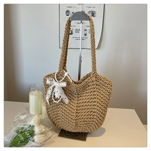 Detail of khaki woven tote bag with white lace bow and a cute lamb doll charm