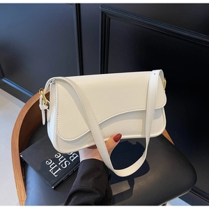 Détail du sac à bandoulière en cuir blanc avec boucle dorée et rabat au design incurvé