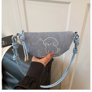 Détail du sac en denim bleu clair avec broderie chien blanc et texte born lover brodé