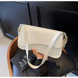 Détail du sac à bandoulière blanc avec boucle métallique dorée et texture en cuir lisse