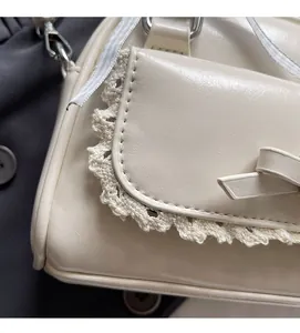Close-up of cream PU leather handbag with delicate knit lace edges and a sweet bow detail