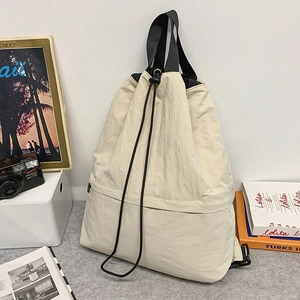 Detailansicht von cremefarbenem Nylon-Kordelzug-Rucksack mit Seitentasche und Tragegriffen