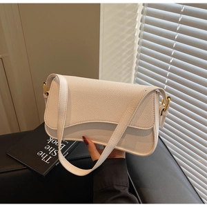 Close-up of off-white lychee grain leather underarm bag with gold metal buckle detail