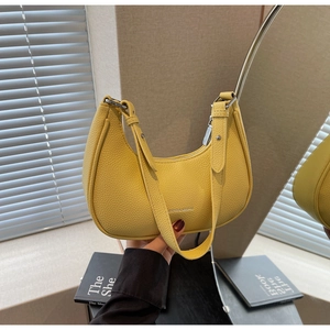 Detail of bright yellow lychee leather hobo bag with silver zipper and slim strap