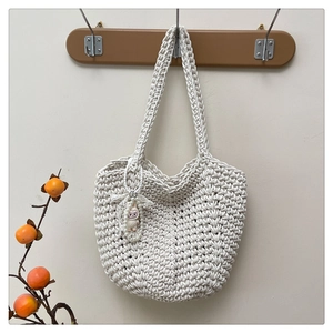 Close-up of woven tote bag texture with pearl lace Labubu cartoon character pendant