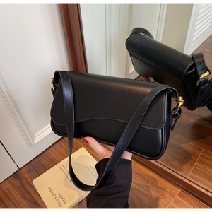 Détail du sac sous le bras en similicuir mat noir avec boucle et ferrures dorées