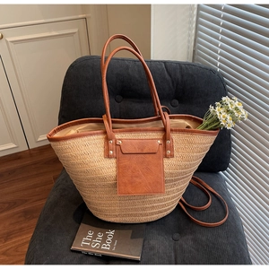 Detail of straw tote bag with brown faux leather pocket and stylish metal rivets