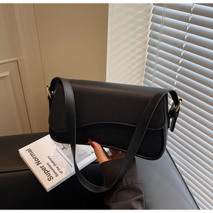 Close-up of black lychee grain leather underarm bag with gold metal adjustment buckle