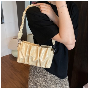 Detail of cream pleated cloud bag with thick braided strap and silver metal hardware