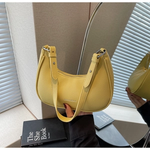 Detail of bright yellow crescent bag showing high-quality lychee grain texture