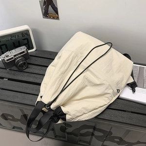 Detailansicht des cremefarbenen Nylon-Rucksacks mit Kordelzug, Reißverschluss und Metallhaken