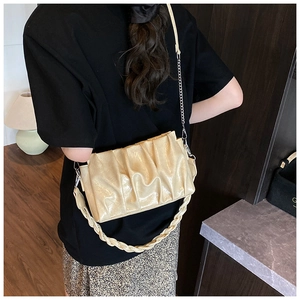 Detail of cream beige pleated cloud bag with silver chain and braided handle on model