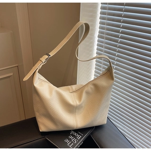 Detail of cream crossbody bag showing premium lychee texture and adjustable strap buckle