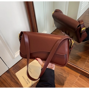 Détail du sac sous l'aisselle vintage rouge foncé avec boucle dorée et cuir mat doux