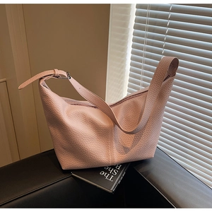 Detail of dusty pink pebbled leather crossbody bag with adjustable silver buckle strap