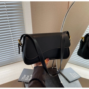 Détail du sac sous l'aisselle en cuir mat noir avec boucle dorée de style vintage