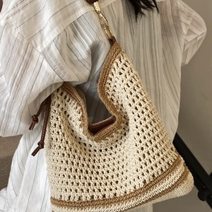 Minimalist beige woven tote bag with brown trim and gold chain strap detail
